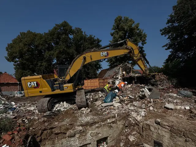 Bagger reißt ein Gebäude ab, davor aufgeschichteter Bauschutt und zwei Arbeiter