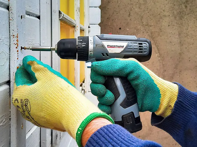 Handwerker verschraubt mit dem Akkuschrauber eine Fassadenverkleidung