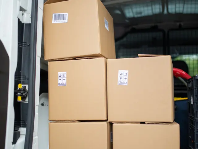 Umzugskartons stehen gestapelt im Laderaum eines Transporters